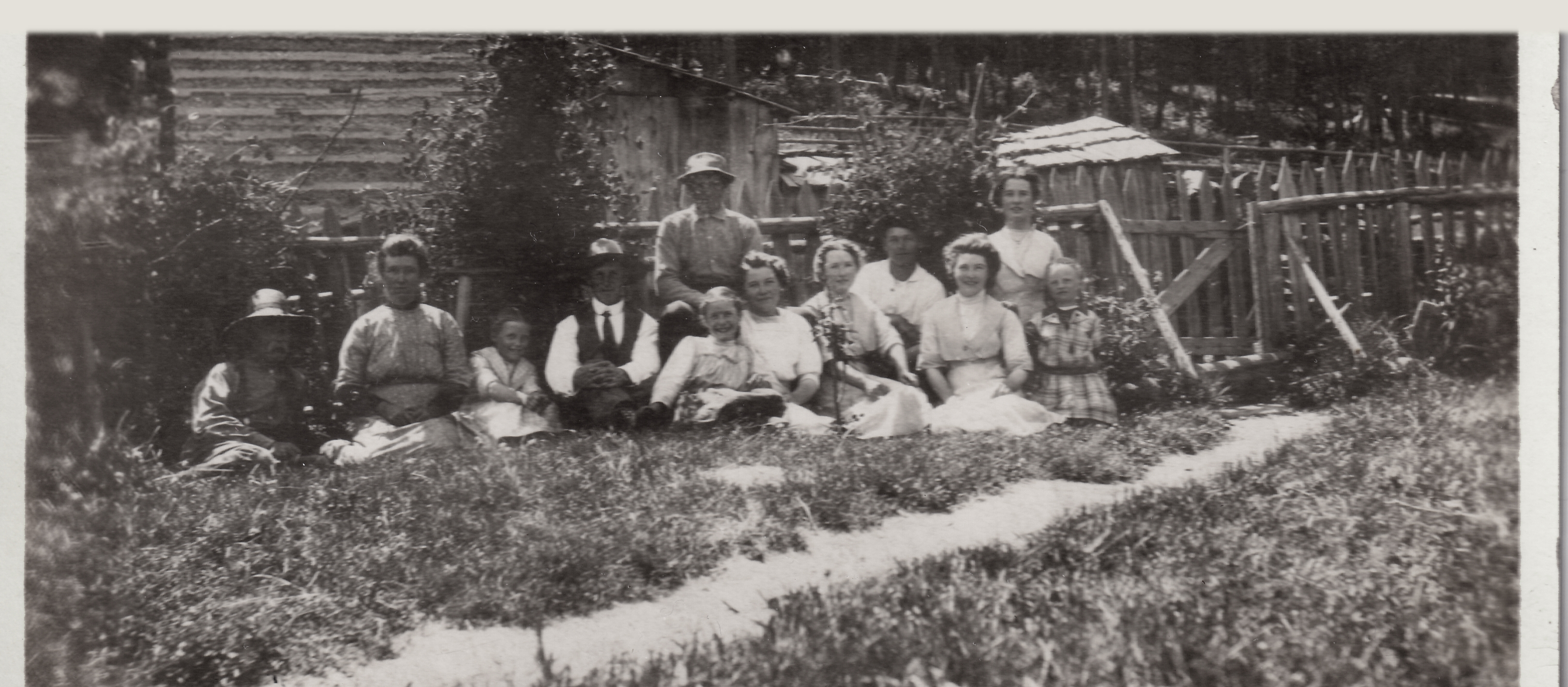 1900s Family sat in front of fence